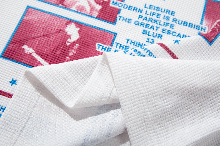 Close-up of the white waffle-knit shirt fabric and folded edge over the printed front graphic