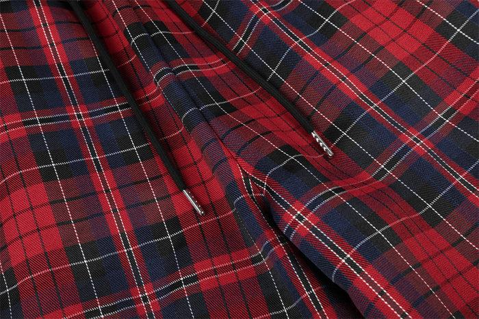 Close-up of the plaid pants showing the black drawstring and slanted front pocket opening