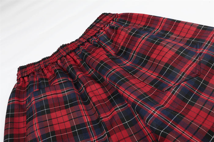 Detailed view of the elastic waistband and gathered red plaid fabric on the wide-leg pants
