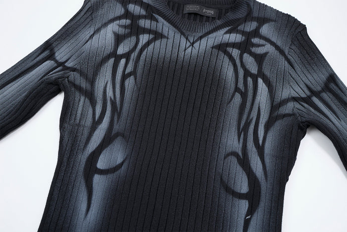 Close-up of the black sweater front showing vertical ribbing and abstract gray graffiti graphics