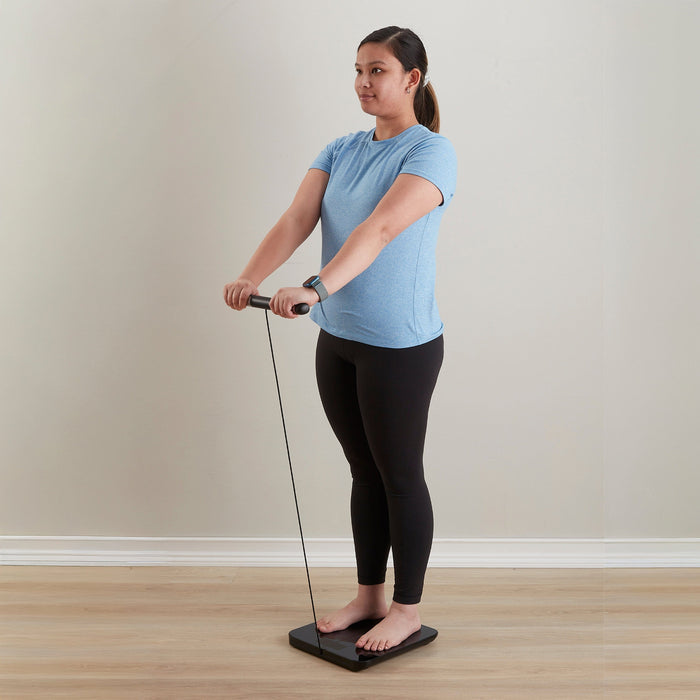 Woman in blue top standing on a smart body composition scale showing body metrics