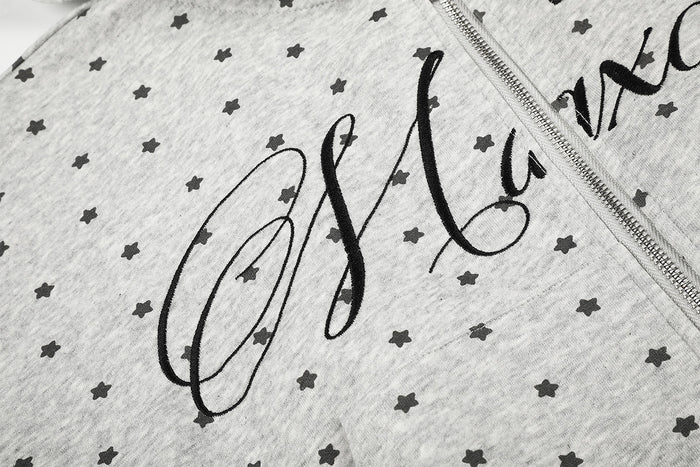 Close-up of black script and cross graphic printed across the gray star-patterned hoodie front