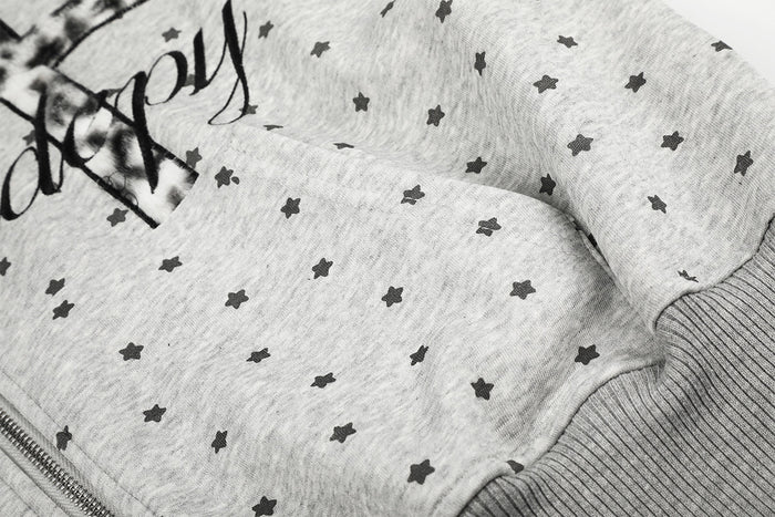 Close-up of the gray hoodie sleeve and ribbed cuff with scattered black stars and partial front graphic