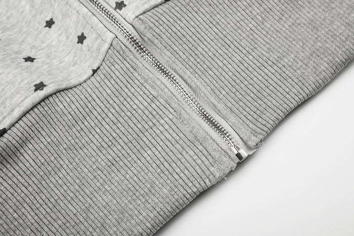 Close-up of the hoodie front zipper meeting the wide ribbed gray waistband