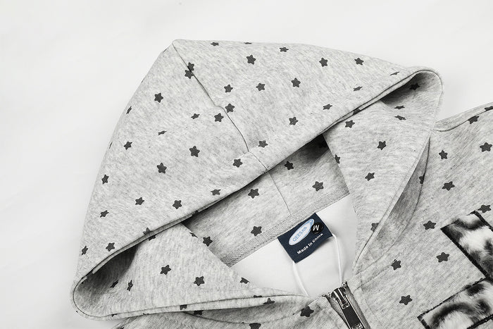 Close-up of the star-print hood, inner label, and metal zipper on the gray cropped hoodie