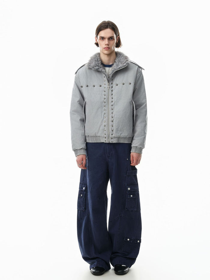 Full-length model view of a light gray studded bomber jacket with faux fur collar