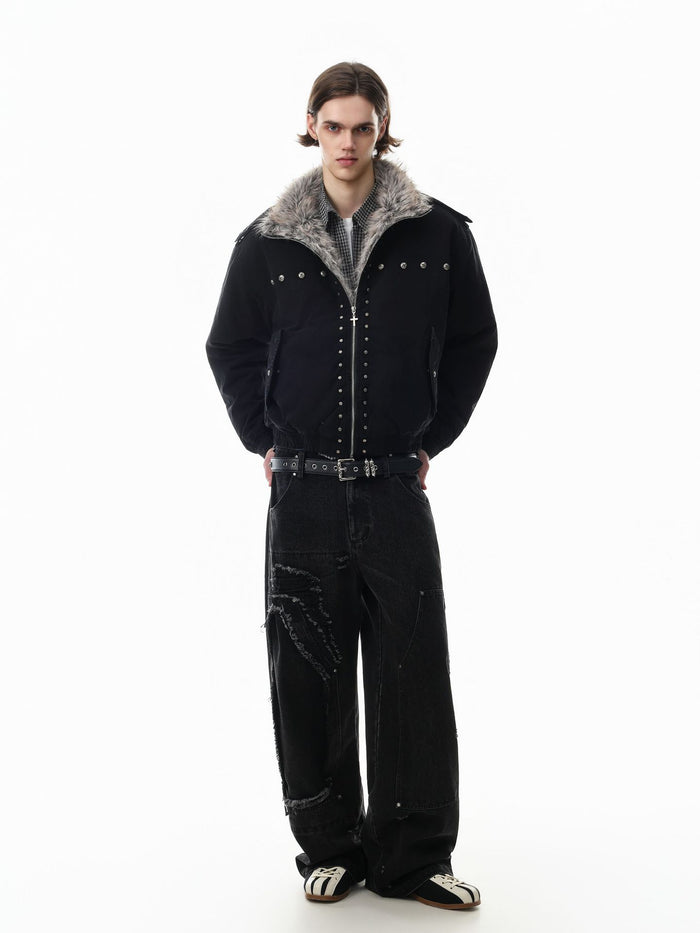Full-length model view of a black studded bomber jacket with gray faux fur collar