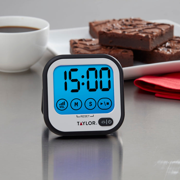 Super-Loud touchscreen digital timer with a bright blue display; cup of coffee and chocolate brownies in the background
