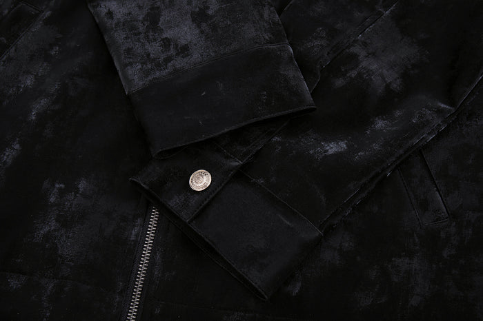 Close-up of the black velvet jacket sleeve cuff with a silver button, zipper edge, and textured fabric