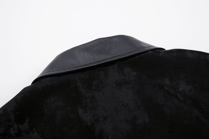 Close-up of the black leather collar resting over the textured velvet jacket body