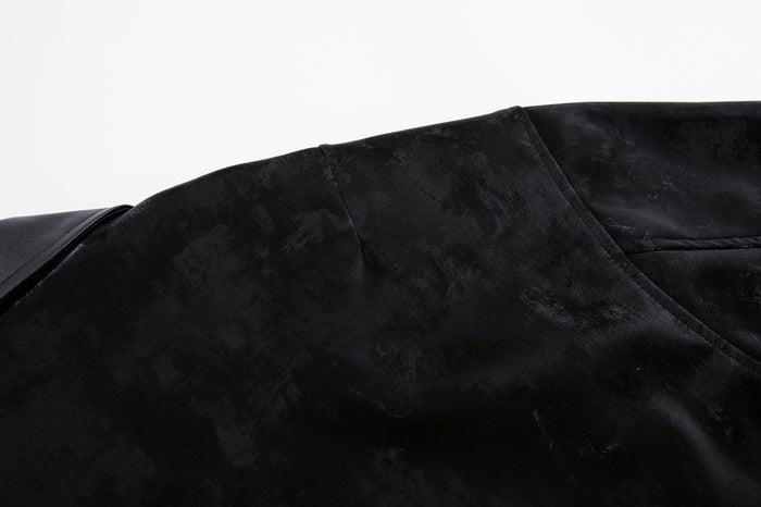 Close-up of the black velvet jacket shoulder and collar area showing stitched seams and textured fabric