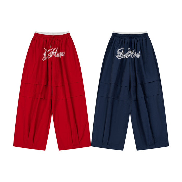 Oversized wide-leg baggy pants with double waistband and script embroidery in navy and red colorways