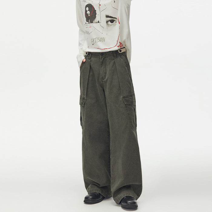 Army green wide-leg cargo pants worn from the front, showing pleats, side pockets, and oversized trouser legs