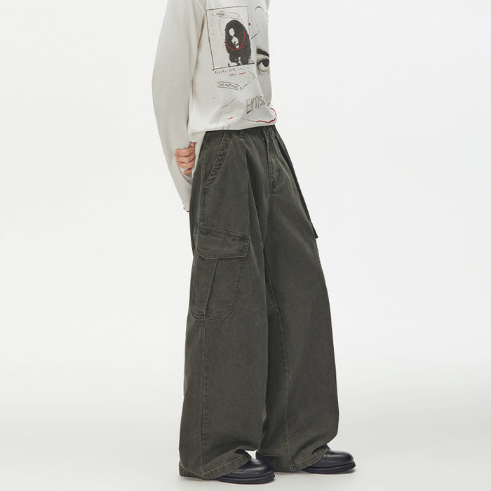 Army green baggy cargo pants shown from the side, highlighting pleats, flap pockets, and relaxed wide-leg fit