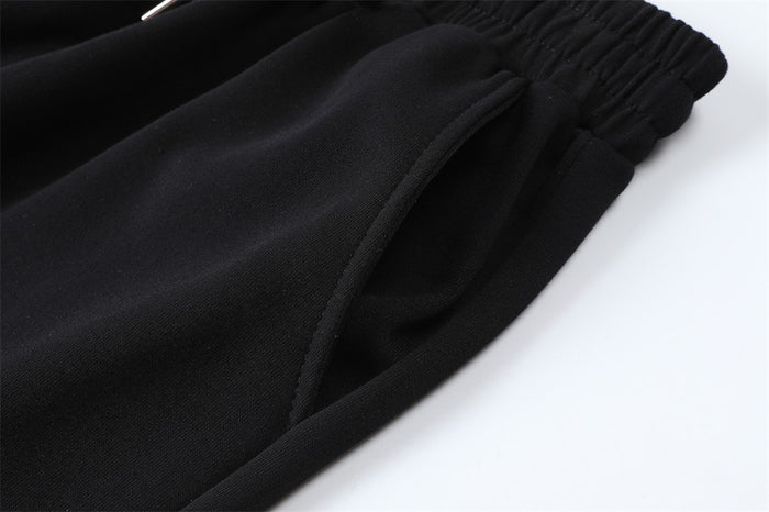 Close-up of the black sweatpants side seam showing the angled hand pocket opening