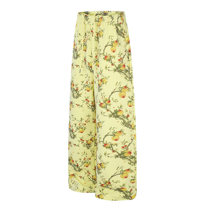 Angled side view of pale yellow wide-leg pants with peach and blossom branch print