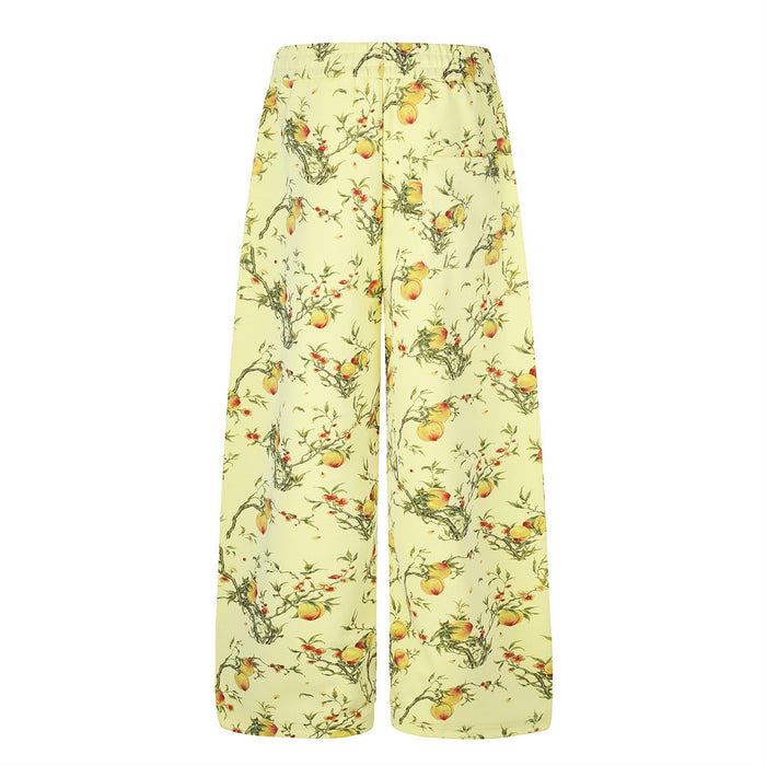 Front view of relaxed straight-fit wide-leg pants in pale yellow with peach branch artwork