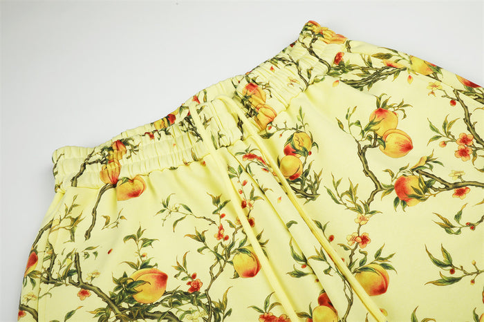 Close-up of the elastic waistband and gathered front on pale yellow peach-print pants