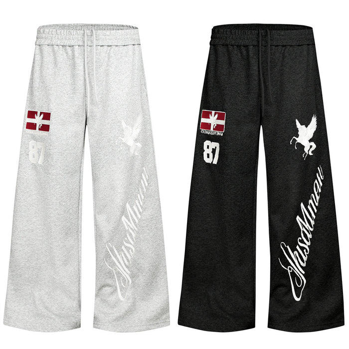 Wide-leg sweatpants in gray and black with elastic waists, red letter patches, white Pegasus graphics and script