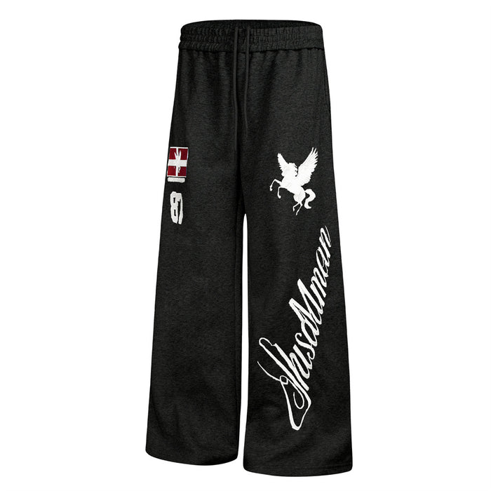 Black wide-leg sweatpants angled front view showing the red patch, white Pegasus embroidery and vertical script