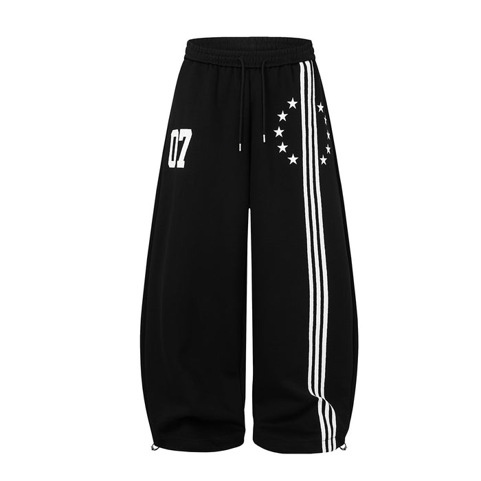 Black wide-leg sweatpants front view with white triple side stripes, star print and 07 graphic
