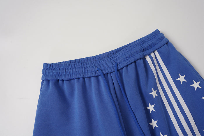 Close-up of blue sweatpants waistband, drawstring and upper side panel with white stripes and stars