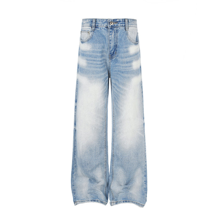 Front view of wide-leg light blue washed denim jeans with faded gradient patches and five-pocket styling