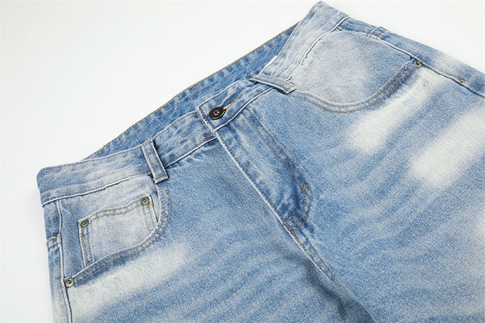 Close-up of the jeans front waist showing belt loops, button closure, front pockets, and faded blue denim