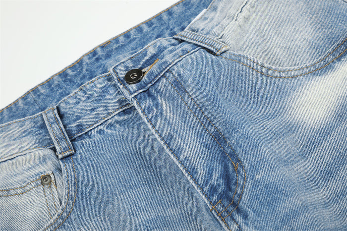 Detailed front waist view showing the metal button, belt loop, zipper fly seam, and light blue washed denim