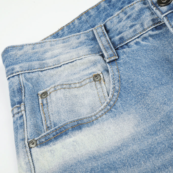 Close-up of the front coin pocket with metal rivets, belt loop, contrast stitching, and faded blue denim