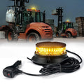 Yellow warning light with power cord in front of a forklift in an industrial setting