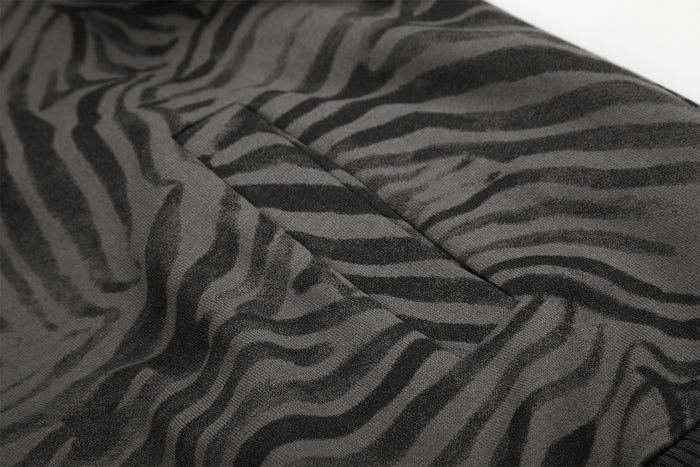 Close-up of the grey and black zebra-print fabric and stitched pocket opening on the jacket