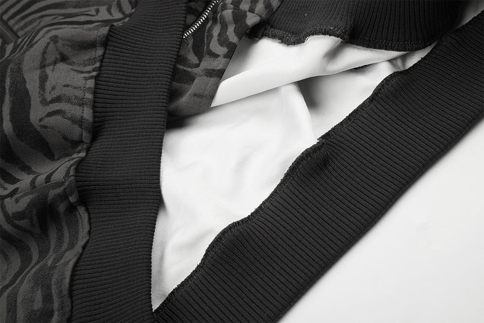Interior close-up showing the white lining, black ribbed hem, and zipper edge of the jacket