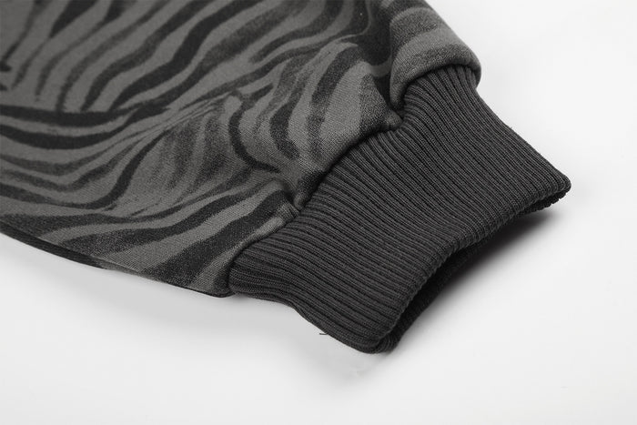 Close-up of the black ribbed sleeve cuff attached to the grey zebra-print jacket fabric